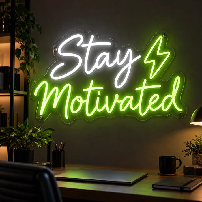 Neon LED Schild mit Schriftzug „Stay Motivated“ und Blitz in Weiß und Grün über dem Schreibtisch im Home Office