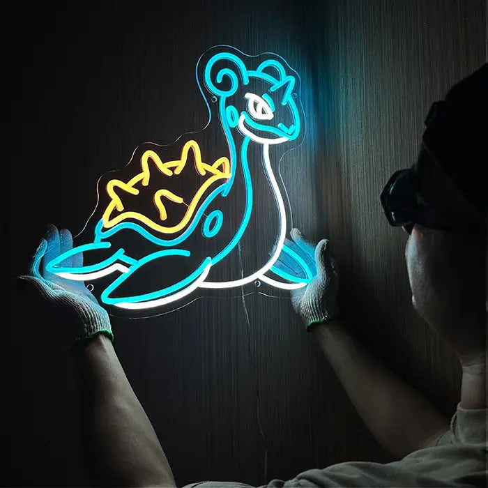 Pokémon Lapras Neon LED Schild wird an der Wand ausgerichtet, eine Person mit Handschuhen hält es fest