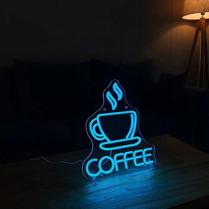 Coffee Tasse Neon LED Schild auf Standfüßen auf einem Holztisch, dahinter Sofa und Stehlampe