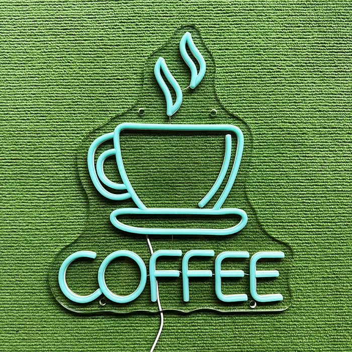Coffee Tasse Neon LED Schild ausgeschaltet auf grünem Untergrund, komplette Kontur erkennbar