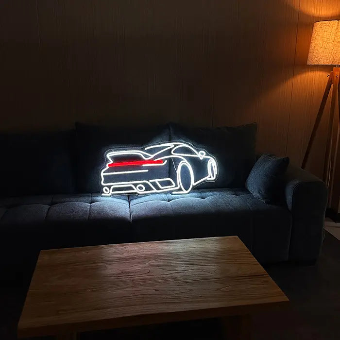 GT-Sportwagen Neon LED Schild auf einem dunklen Sofa aufgestellt, davor ein Couchtisch