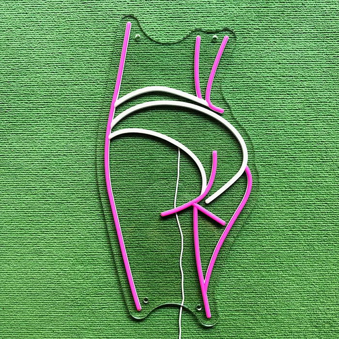 Sexy Boogie Neon LED Schild ausgeschaltet auf grünem Untergrund, komplette Kontur erkennbar