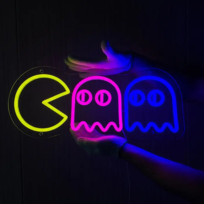 Retro Ghosts Neon LED Schild wird mit Handschuhen an eine dunkle Holzwand gehalten
