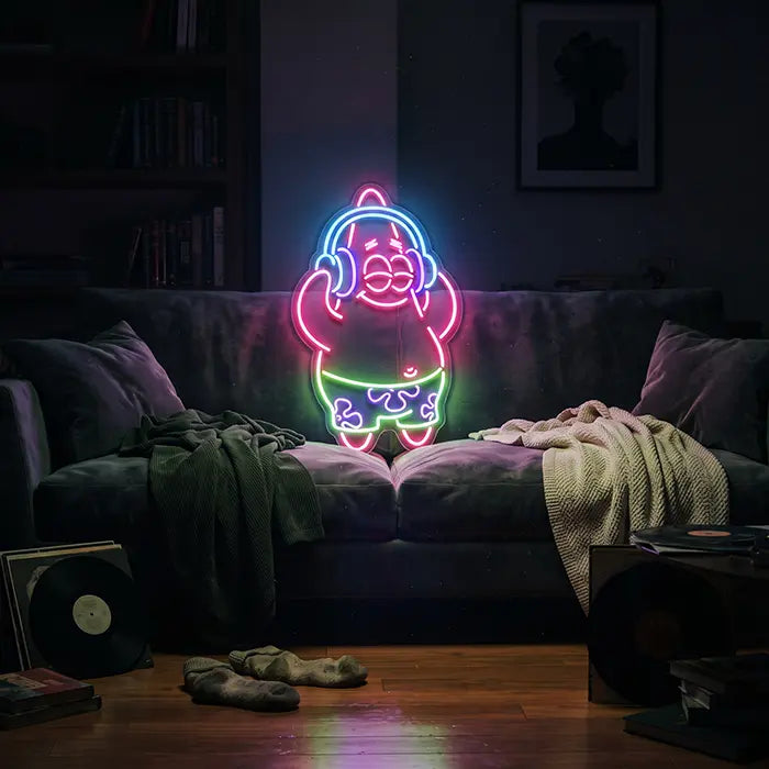 Patrick Musik Neon LED Schild über dem Sofa im Wohnzimmer, daneben Kuscheldecken und Schallplatten
