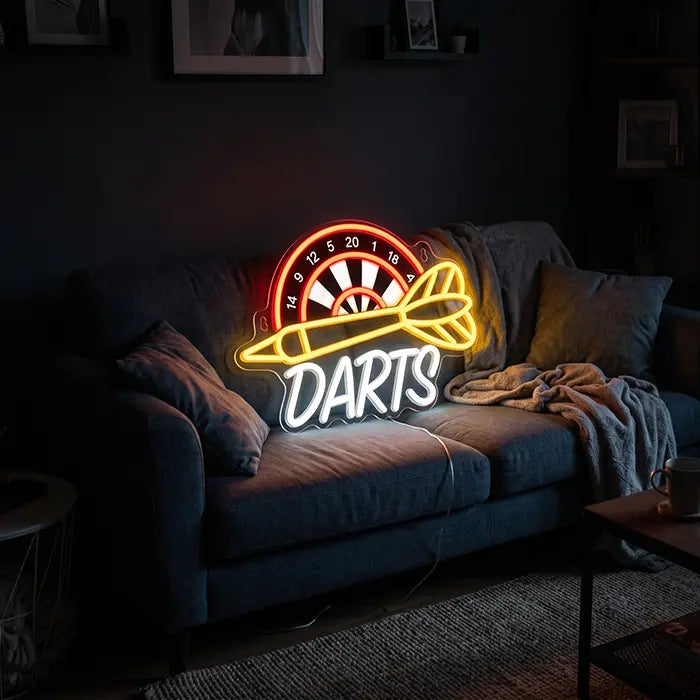 Darts Neon LED Schild mit UV-Druck auf einem grauen Sofa mit Kissen und Decke aufgestellt