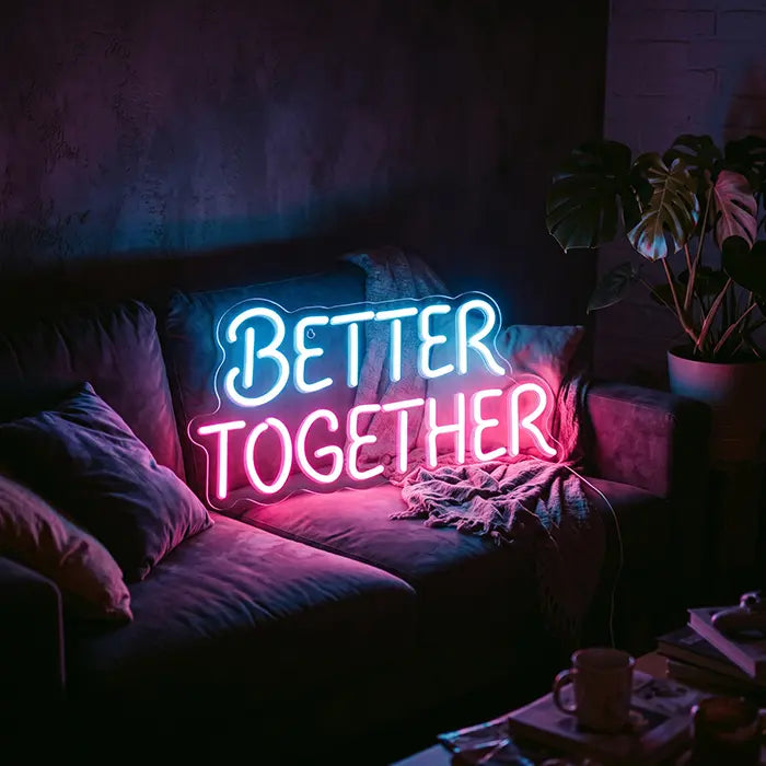 Better Together Neon LED Schild in Blau-Pink auf einem Sofa mit Kissen