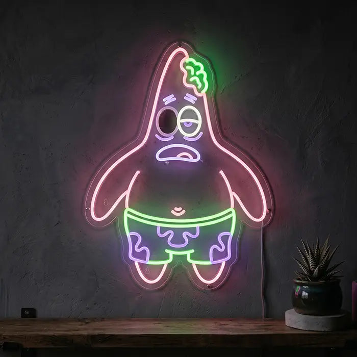 Patrick Zombie Neon LED Schild hängt über einer Holzkommode mit Sukkulente an einer dunklen Wand