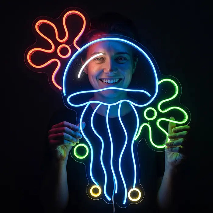 Qualle mit Blumenwolken Neon LED Schild von einer lächelnden Person vor dem Gesicht gehalten