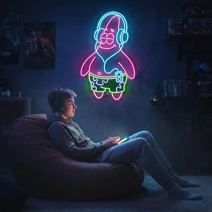 Patrick Kopfhörer Neon LED Schild im Gaming-Zimmer, davor ein Junge mit Kopfhörern auf dem Sitzsack