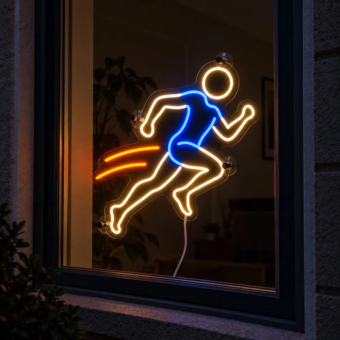 Abendläufer Neon LED Schild im Fenster, von der nächtlichen Straße aus gesehen