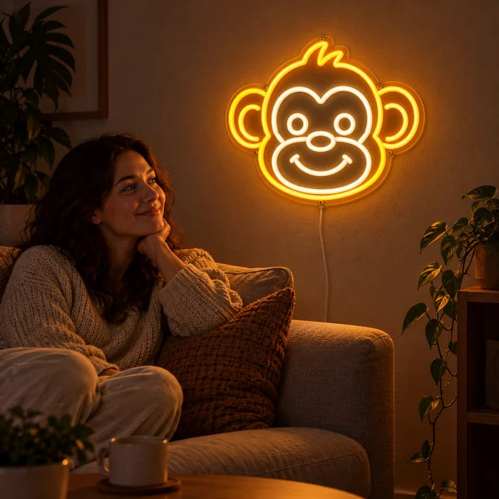 Affengesicht Neon LED Schild an der Wohnzimmerwand, davor entspannt eine Person auf dem Sofa