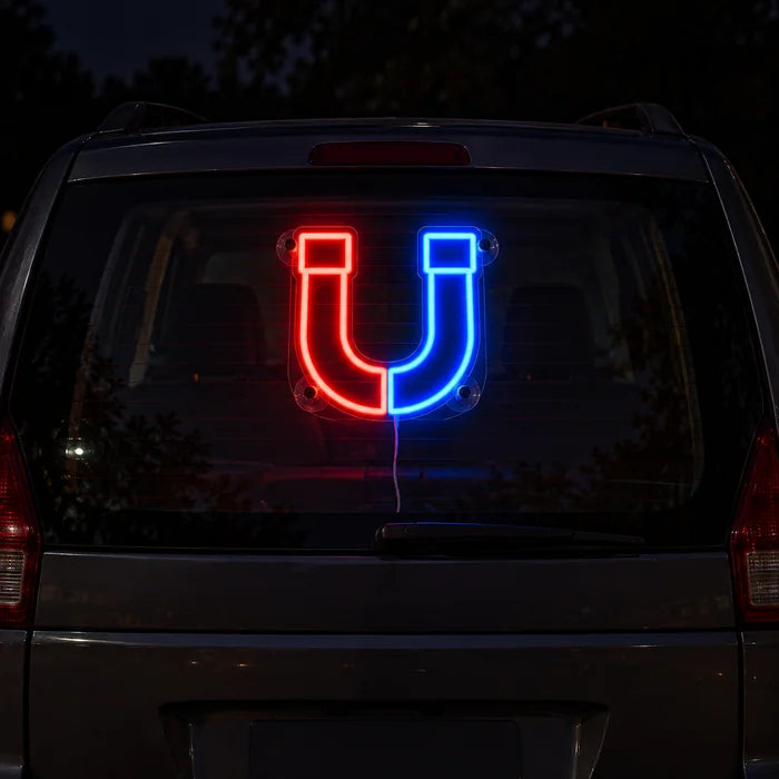 Anziehungskraft Neon LED Schild an der Heckscheibe eines Autos bei Nacht