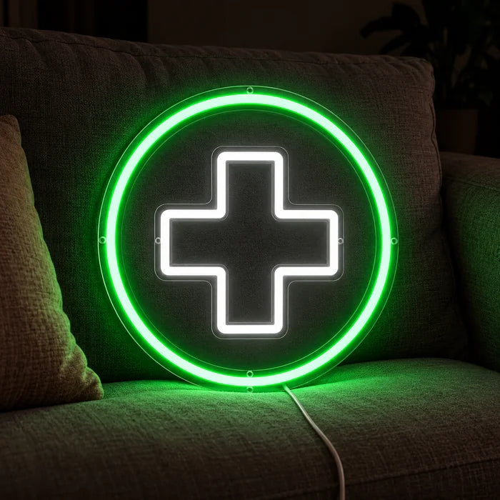 Apothekenkreuz Neon LED Schild auf einem gemütlichen Sofa zwischen Kissen und Decke