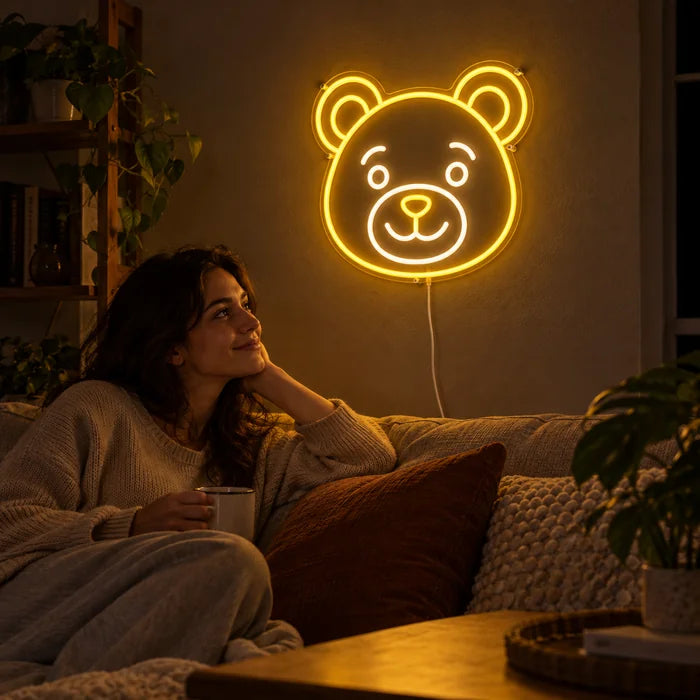 Bärenlächeln Neon LED Schild an der Wohnzimmerwand, davor entspannt eine Person auf dem Sofa