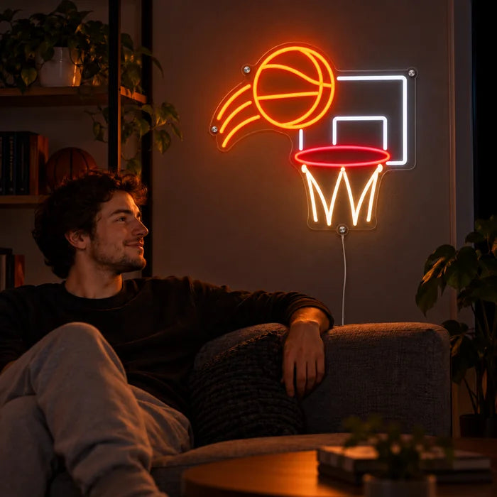 Basketballwurf Neon LED Schild an der Wohnzimmerwand, davor entspannt eine Person auf dem Sofa