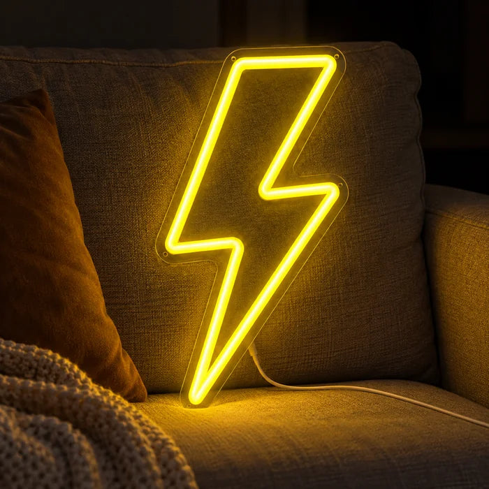 Blitz Neon LED Schild auf einem gemütlichen Sofa zwischen Kissen und Decke