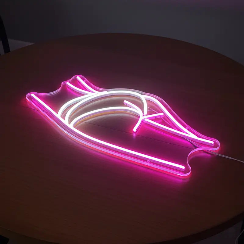 Auffälliges LED-Schild mit dem Umriss eines Körpers, wobei die Akzente und Linien in Pink und leuchtendem Weiß sind.