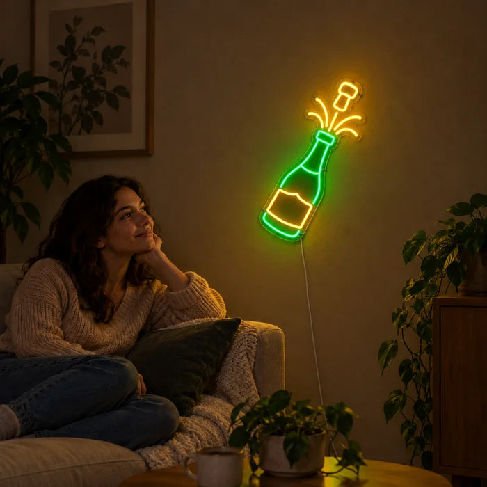 Champagner Neon LED Schild an der Wohnzimmerwand, davor entspannt eine Person auf dem Sofa