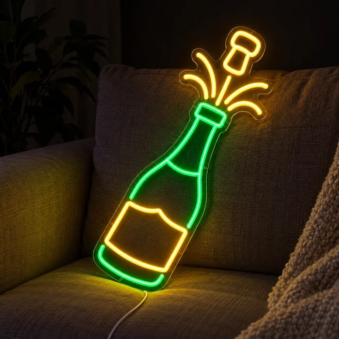 Champagner Neon LED Schild auf einem gemütlichen Sofa zwischen Kissen und Decke