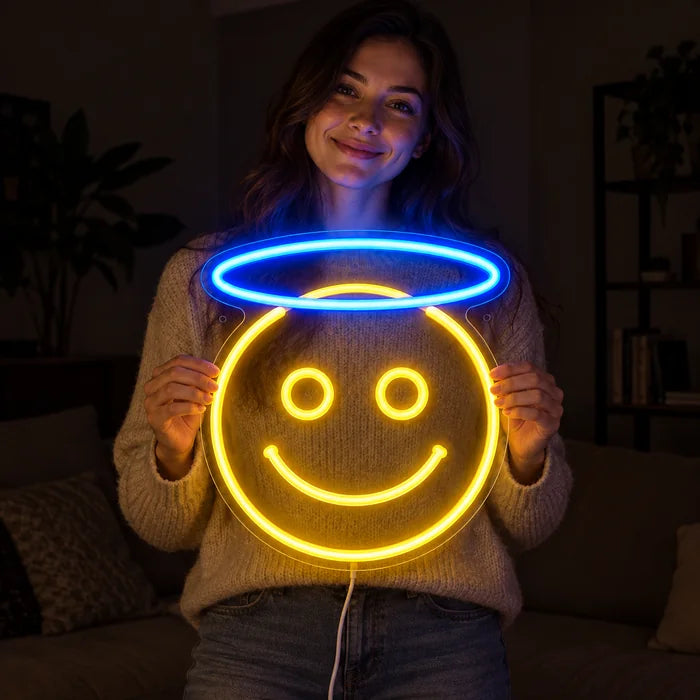 Engel-Smiley Neon LED Schild in den Händen einer lächelnden Frau vor dunklem Hintergrund