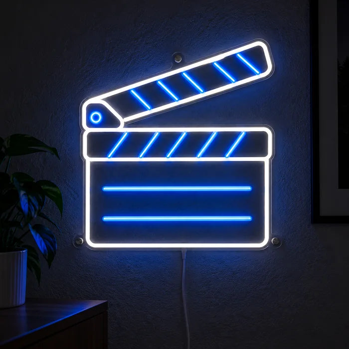 Filmklappe Neon LED Schild leuchtend an einer dunklen Wand, Nahaufnahme mit Anschlusskabel