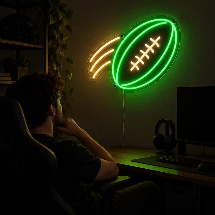 Football im Flug Neon LED Schild über dem Gaming-Schreibtisch, davor ein Spieler im Gaming-Stuhl