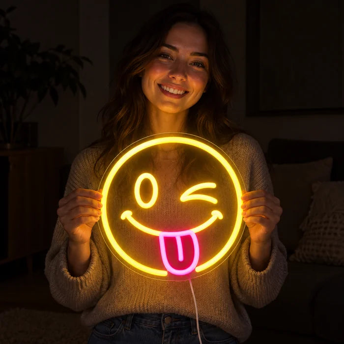 Frecher Smiley Neon LED Schild in den Händen einer lächelnden Frau vor dunklem Hintergrund