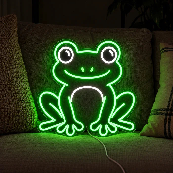 Froschfreund Neon LED Schild auf einem gemütlichen Sofa zwischen Kissen und Decke
