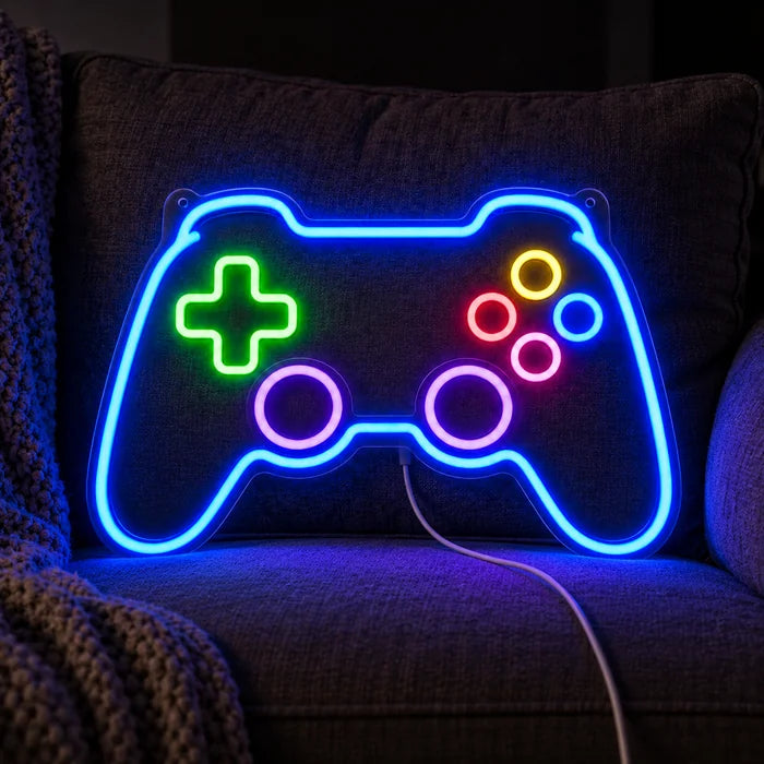 Gamecontroller Neon LED Schild auf einem gemütlichen Sofa zwischen Kissen und Decke