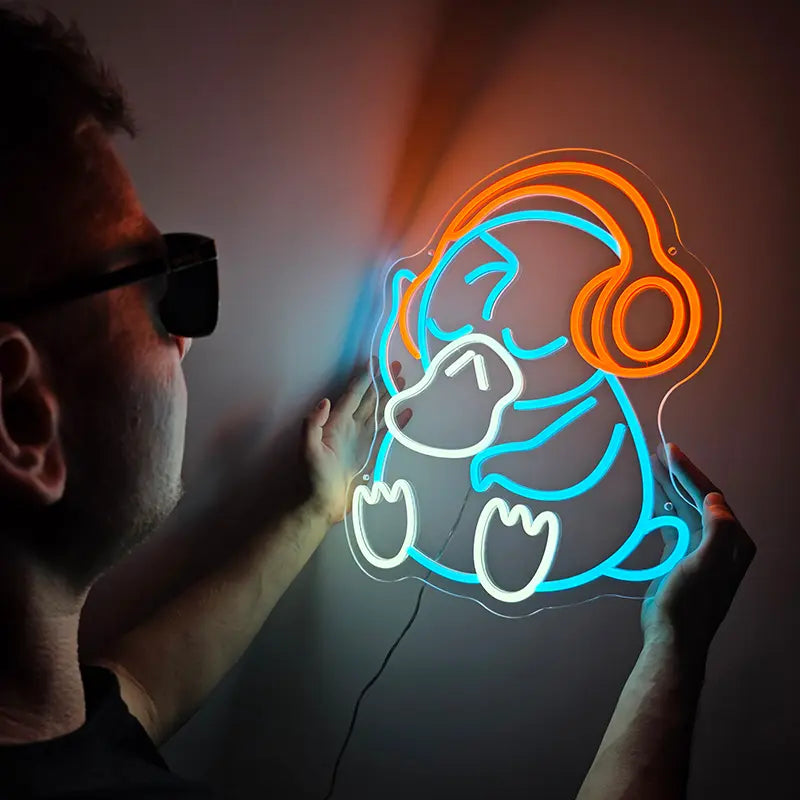 Buntes Pokémon Neon-Kunstwerk von Enton in sitzender Pose mit hellblauen Konturen und orangefarbenen Kopfhörern
