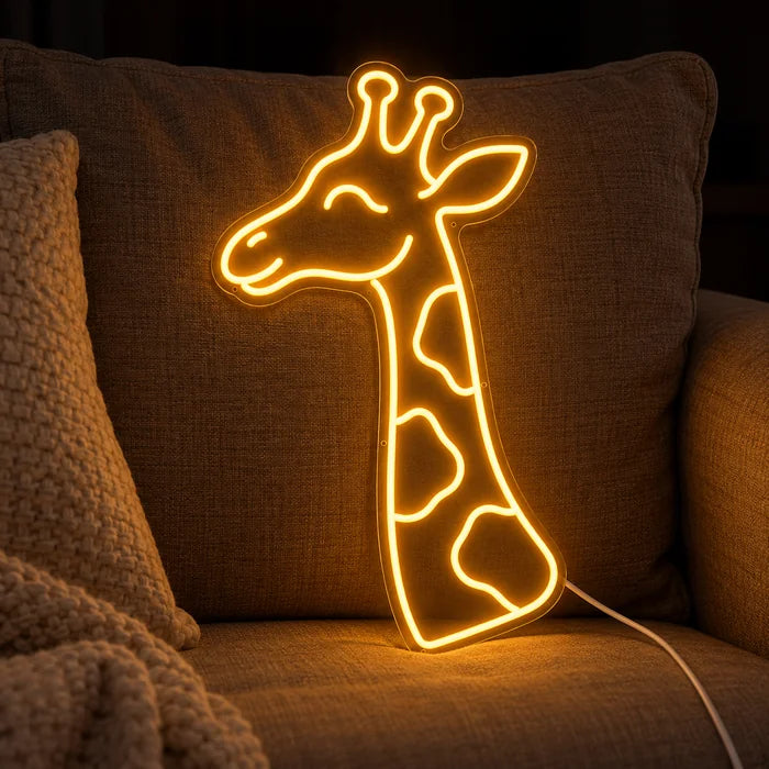 Giraffenkopf Neon LED Schild auf einem gemütlichen Sofa zwischen Kissen und Decke