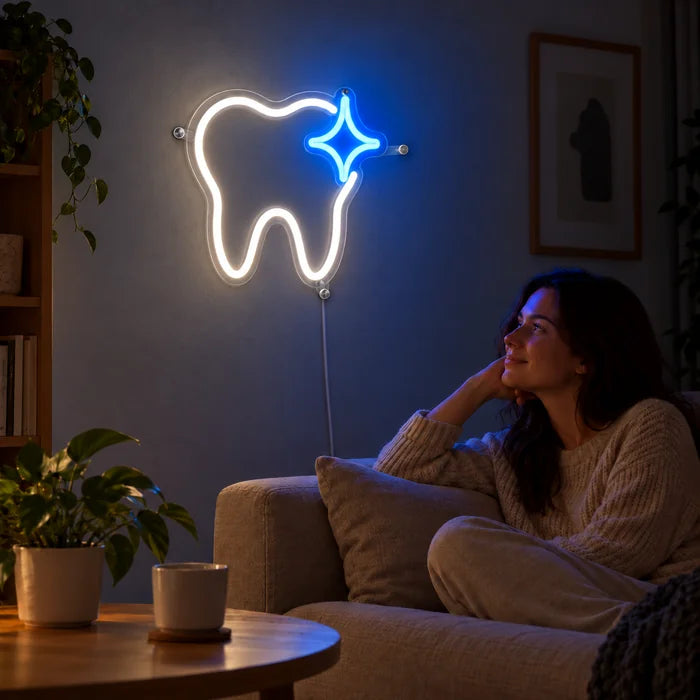 Glänzender Zahn Neon LED Schild an der Wohnzimmerwand, davor entspannt eine Person auf dem Sofa