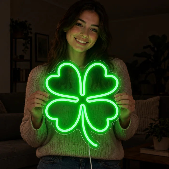 Glücksklee Neon LED Schild in den Händen einer lächelnden Frau vor dunklem Hintergrund