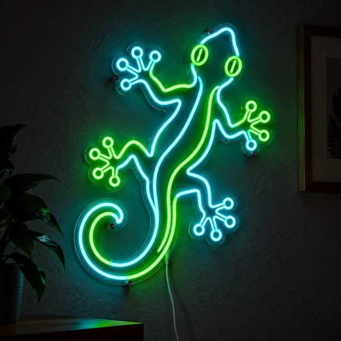 Grüner Gecko Neon LED Schild leuchtend an einer dunklen Wand, Nahaufnahme mit Anschlusskabel
