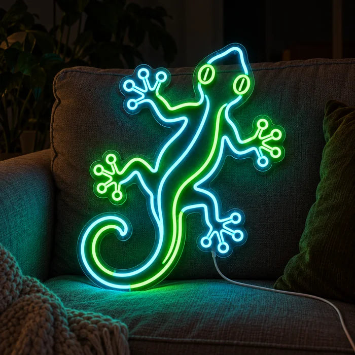Grüner Gecko Neon LED Schild auf einem gemütlichen Sofa zwischen Kissen und Decke