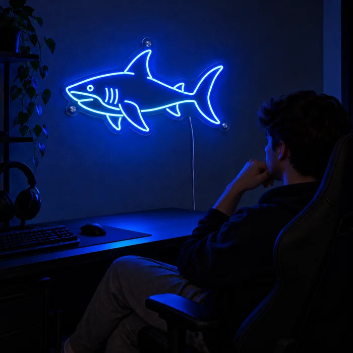 Hai Neon LED Schild über dem Gaming-Schreibtisch, davor ein Spieler im Gaming-Stuhl