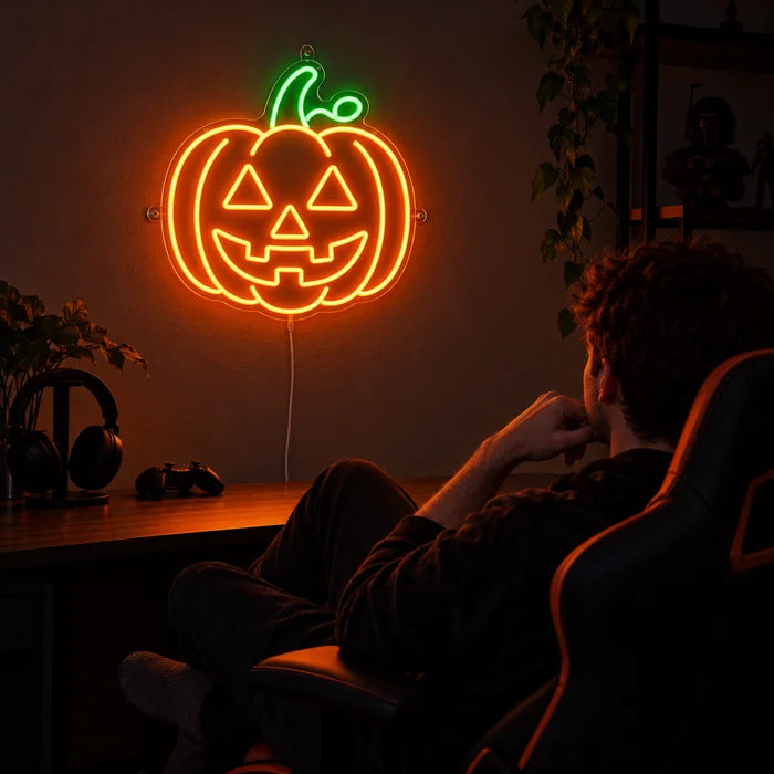 Halloween-Kürbis Neon LED Schild über dem Gaming-Schreibtisch, davor ein Spieler im Gaming-Stuhl