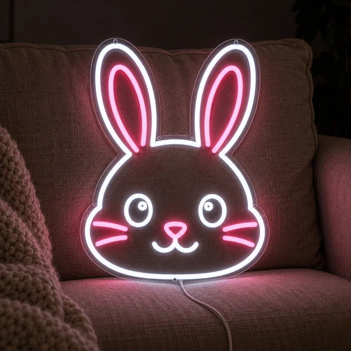 Hasengesicht Neon LED Schild auf einem gemütlichen Sofa zwischen Kissen und Decke