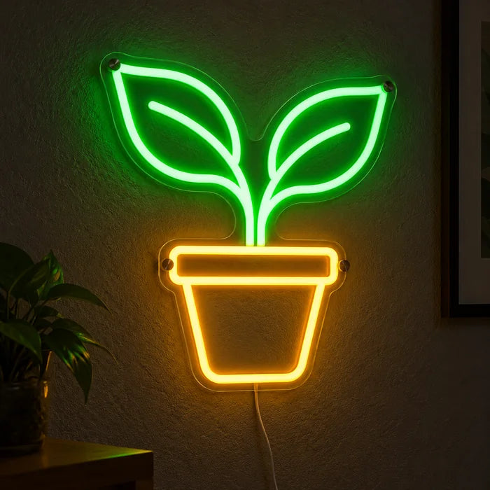 Kleiner Sprössling Neon LED Schild leuchtend an einer dunklen Wand, Nahaufnahme mit Anschlusskabel