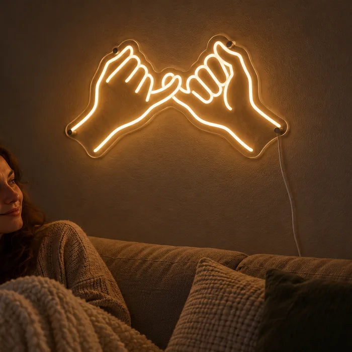 Kleines Versprechen Neon LED Schild an der Wohnzimmerwand, davor entspannt eine Person auf dem Sofa