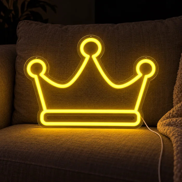 Königskrone Neon LED Schild auf einem gemütlichen Sofa zwischen Kissen und Decke