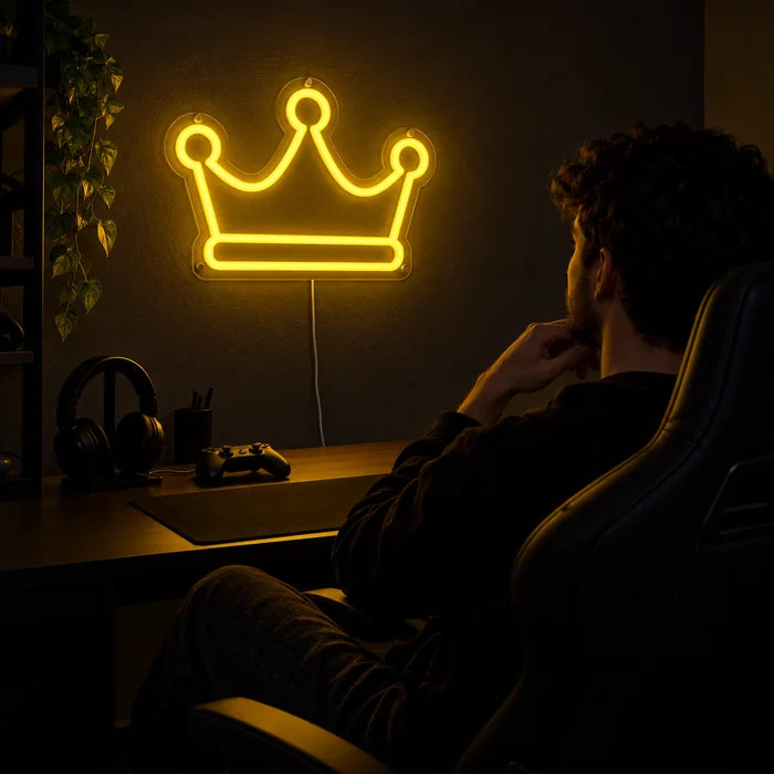 Königskrone Neon LED Schild über dem Gaming-Schreibtisch, davor ein Spieler im Gaming-Stuhl