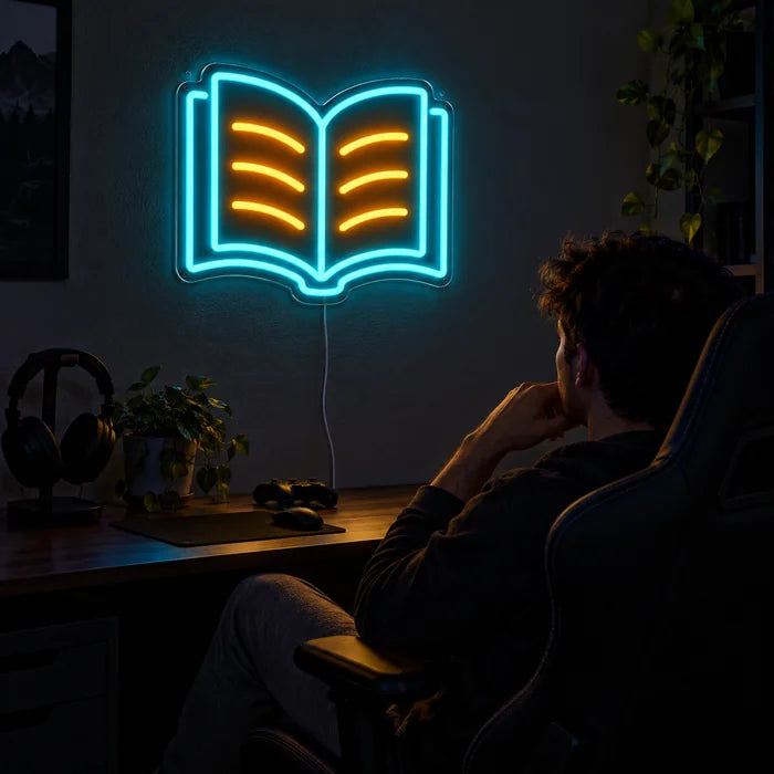 Lesebuch Neon LED Schild über dem Gaming-Schreibtisch, davor ein Spieler im Gaming-Stuhl