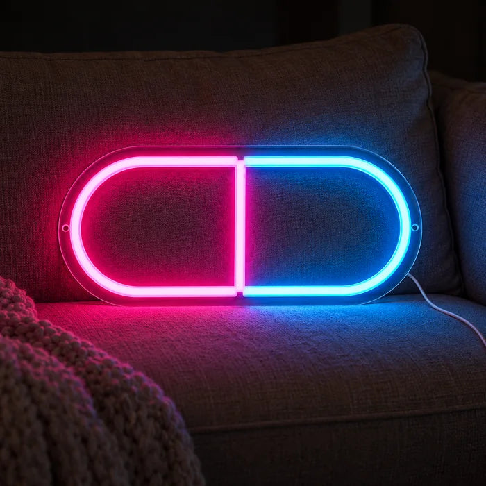 Medikamentenkapsel Neon LED Schild auf einem gemütlichen Sofa zwischen Kissen und Decke