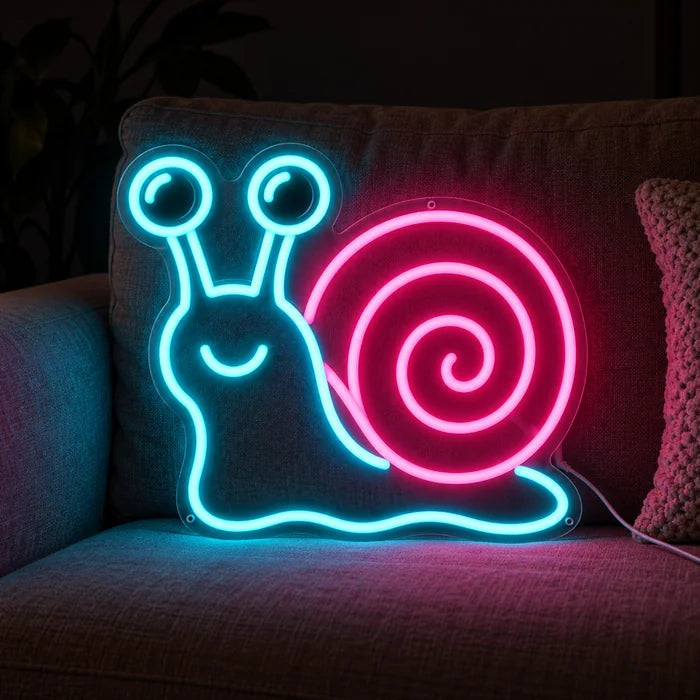 Neon-Schnecke Neon LED Schild auf einem gemütlichen Sofa zwischen Kissen und Decke