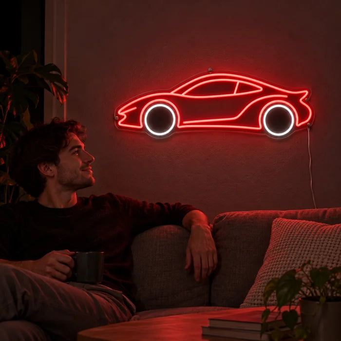 Neon-Sportwagen Neon LED Schild an der Wohnzimmerwand, davor entspannt eine Person auf dem Sofa