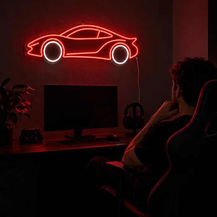 Neon-Sportwagen Neon LED Schild über dem Gaming-Schreibtisch, davor ein Spieler im Gaming-Stuhl