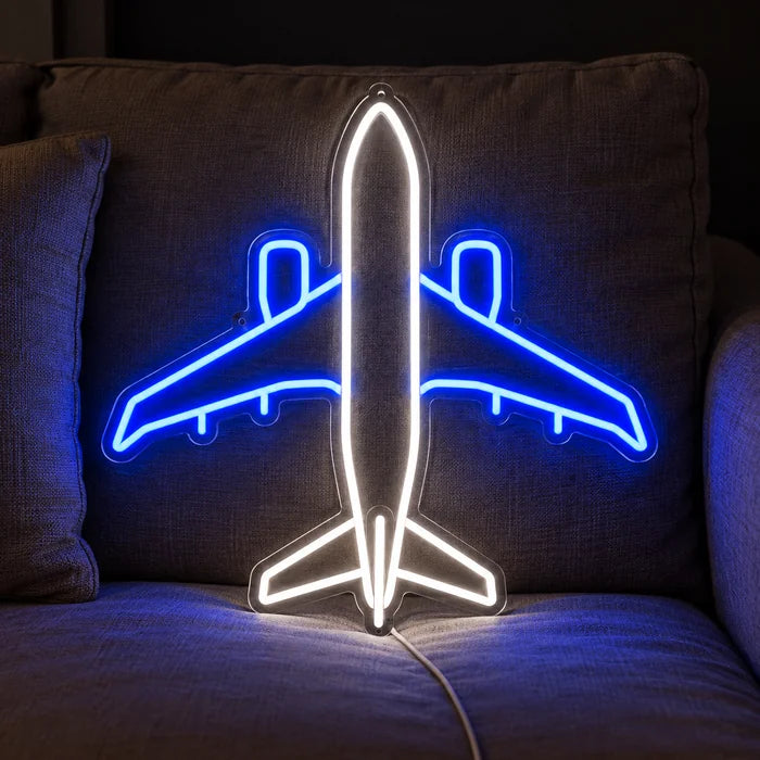 Passagierflugzeug Neon LED Schild auf einem gemütlichen Sofa zwischen Kissen und Decke
