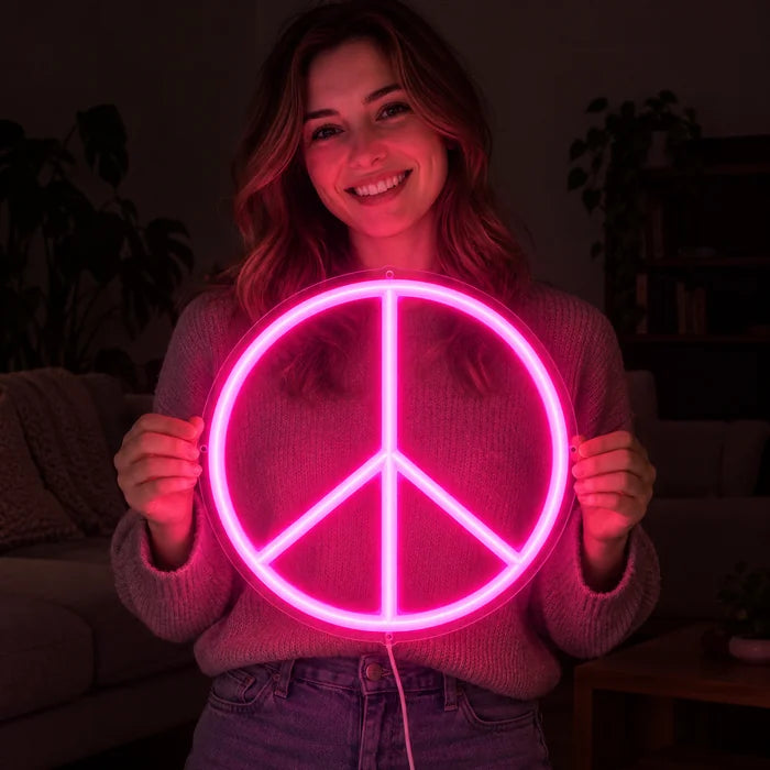 Peace Neon LED Schild in den Händen einer lächelnden Frau vor dunklem Hintergrund