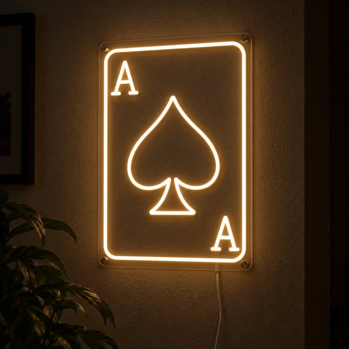 Pik-Ass Neon LED Schild leuchtend an einer dunklen Wand, Nahaufnahme mit Anschlusskabel